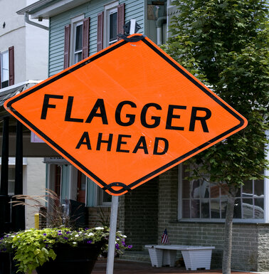 Construction traffic sign warning people a flagger is ahead.
